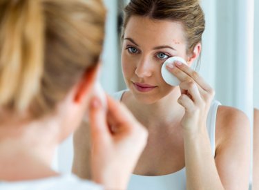 Mujer con piel propensa al acné limpiando su rostro
